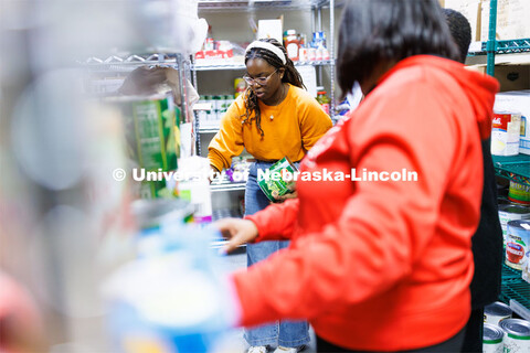 Maryam Sule, a freshman chemical engineering student from Bellevue, sorts food in the store room at 
