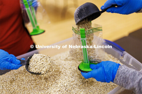 As part of MLK Week events, volunteers scoop oatmeal into bags as they assemble hunger kits. The goa
