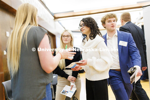 Gabby Gomez Martinez, right, and Kenidy Irvine talk with a recruiter from Charles Schwab during the 