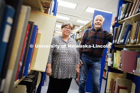 Joanie Barnes (left) and Tom McFarland stand in the stacks of Love Library. The duo founded the Gene