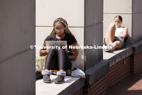 Maryam Ajibola, a freshman from Lockport, Illinios, studies surrounded by spring blooms outside the 