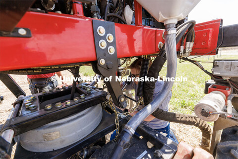 Graduate research assistant Taylor Cross connects the seed box to the planter. The self-driving robo