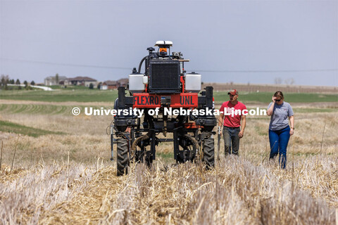 Graduate student Ian Tempelmeyer, red shirt, and graduate research assistant Taylor Cross walk behin