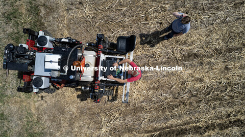 Graduate student Ian Tempelmeyer checks the programming on the planter as it turns for another row. 