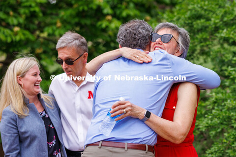 Richard Moberly, dean of law, hugs Jane Green (right) as Ronnie Green talks with Christine Truhe, se