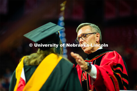 Chancellor Ronnie Green congratulates grad student. 2023 Spring Graduate Commencement in Bob Devaney