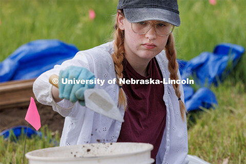 Sophia Huss, sophomore in anthropology, deposits a trowel of soil while excavating a plastic skeleto