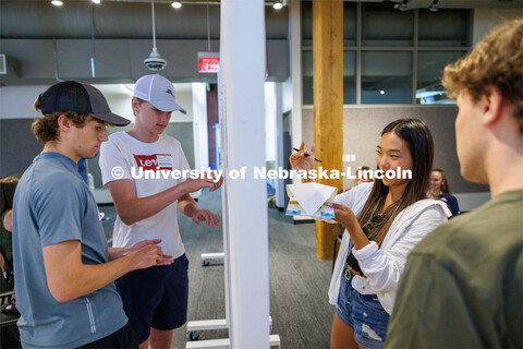 Mattie Purcell, right, a 2023 architecture graduate who is helping with the summer workshop, critiqu