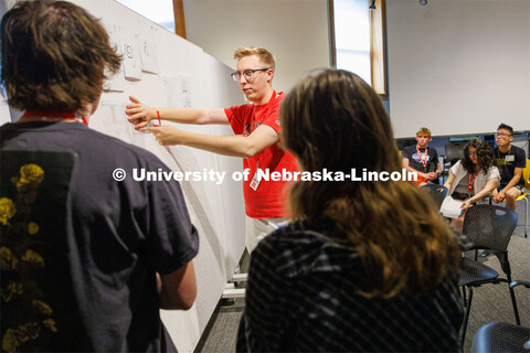 Josh Holstein, a 2023 architecture graduate who is helping with the summer workshop, critiques one o