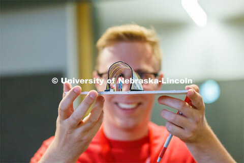 Josh Holstein, a 2023 architecture graduate who is helping with the summer workshop, looks through t