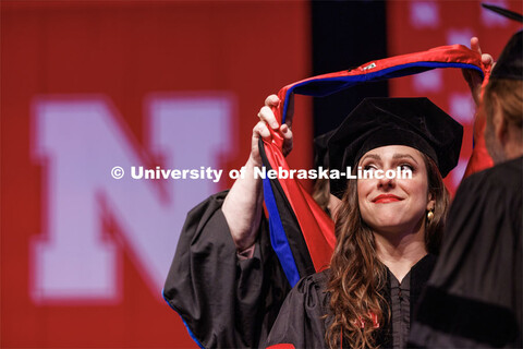 Sonia Lindner watches as her doctoral hood is placed over her head. The University of Nebraska–Lin