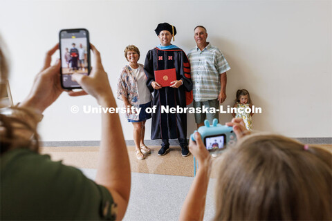 New Doctor of Education Jordan Engle poses for photos with family and friends following the ceremony