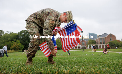 Air Force Lieutenant Colonel Phil Garito plants American flags around a section of the green space n