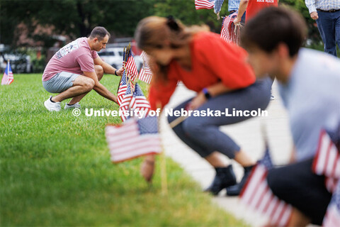 Hunter Bode, a senior and member of the air force ROTC program places flags along the border of the 