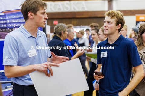 Benjamin Ernster talks with a recruiter for JE Dunn construction at the Career Fair in the Nebraska 