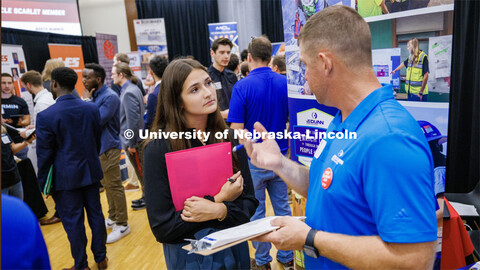 Katie Torres talks with Matt Feik, a recruiter for JE Dunn construction and Nebraska alumni, at the 