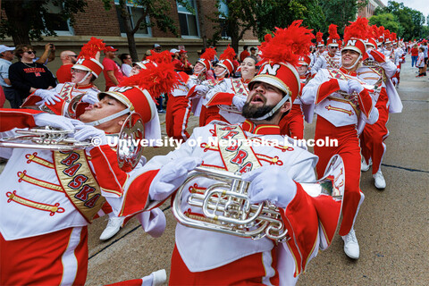 The horn sections limbos down the street as the band marches to the stadium. Nebraska football vs. L