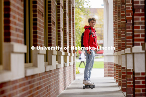 Raikes student skateboarding through the outdoor corridors of the Kauffman Academic Residential Cent