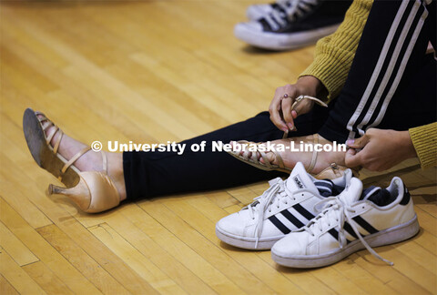 Paige Myers puts her dancing shoes on before the rehearsal. Ballroom Dancing Club works through thei