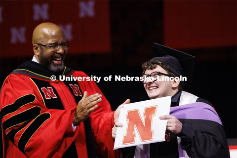 Sebastian Toalson gestures to family and friends after Chancellor Bennett had the last graduate to w