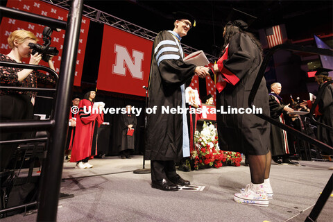 Crandall Blake receives her CEHS diploma from acting dean Nicholas J. Pace. Blake is wearing high to