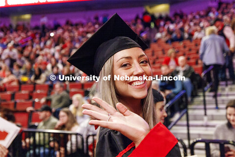 Chloe Schock, CoJMC graduate, waves as she leaves the arena. Winter undergraduate commencement in Pi