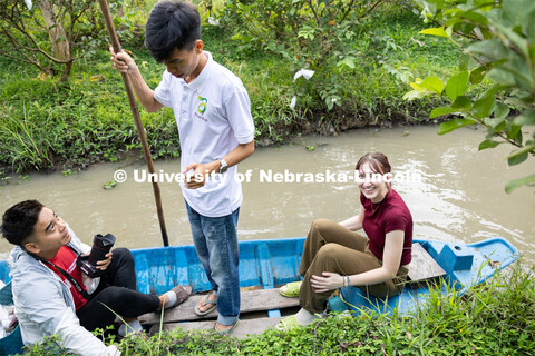 Milana Doné sits in the bow of a boat while working on her story in the Global Eyewitness program. 