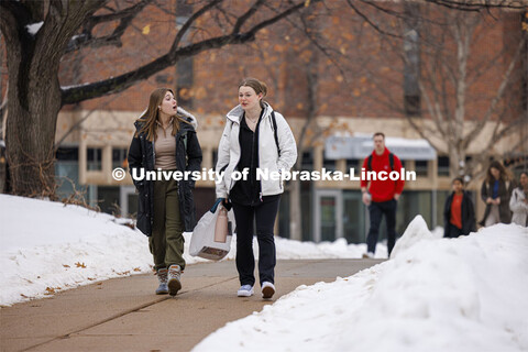 Jayda Feeney, left, and Sara Ehlers walk across campus Tuesday. Snow on city campus. January 23, 202