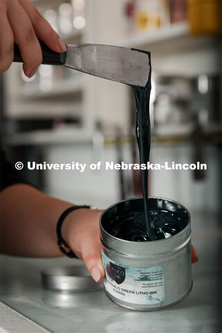 Amy Curtis, a junior in art, in printmaking class in Woods Art Building scoops some ink out of a con