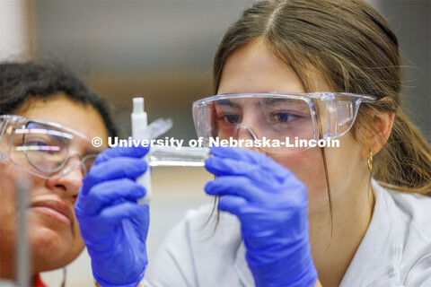 Grace Henry looks at a fluid sample while lab partner Mayra Guerrero looks on. LIFE 120L - Fundament