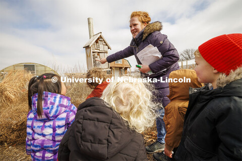 Madeline Williams talks to the children about a bug house in the Backyard Farmer Garden. Students in