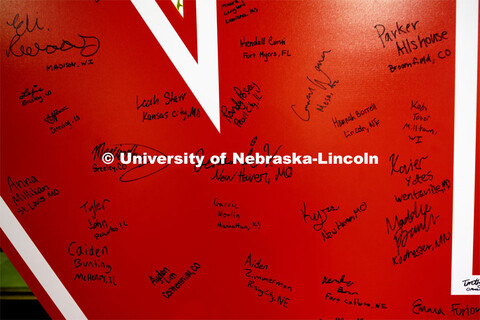 Students attending the Admitted Student Day sign a large “N” poster inside the Nebraska Union. A