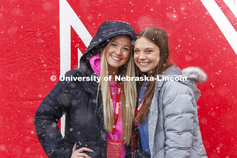 Ava Schmaderer and Makenna Lichty, both of Bennington, Nebraska, try to catch snowflakes on their to