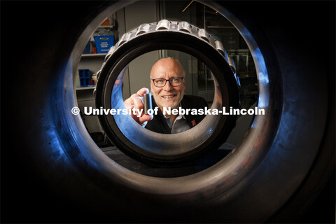 Joe Turner, Professor of Mechanical Engineering, holds a 3-D printed railcar bearing. He is photogra