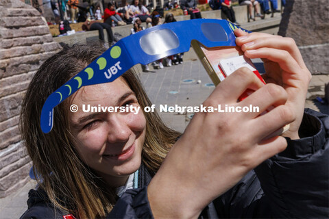 Maria Tamamova uses the eclipse glasses to take a photo with her phone. The Solar Social party to vi