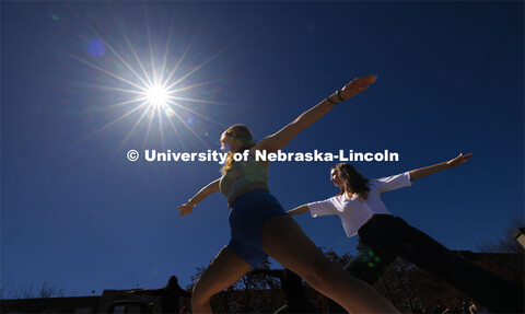 Mekenzie Horihan and Maggie Martin do yoga on the greenspace during the eclipse. The Solar Social pa