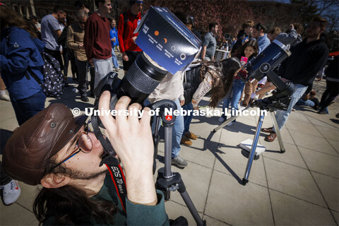 A photographer uses a special lense to photograph the eclipse. The Solar Social party to view the pa