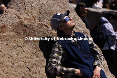 Nathan Benedix leans against the rocks in the Broyhill fountain to watch the eclipse. The Solar Soci