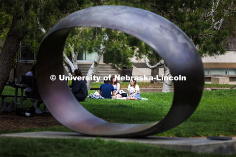 Framed by the sculpture Fragment X-O, Paige Vose, center, Makena Niehaus and Evan Mott (back to came