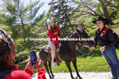 Kyrnlie Simpson laughs as she sits on a horse as her friend, Ophelie Wilson takes a photo of her. Si