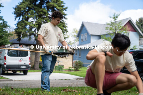 Dominik Kluthe of Delta Phi Fraternity clears away leaves from his rake after clearing up a homeowne