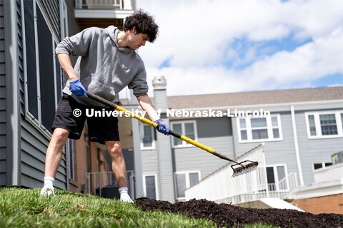 Pi Kappa Alpha’s Grant Breidenbach spreads out mulch at the Van Dorn Villa Retirement Living compl