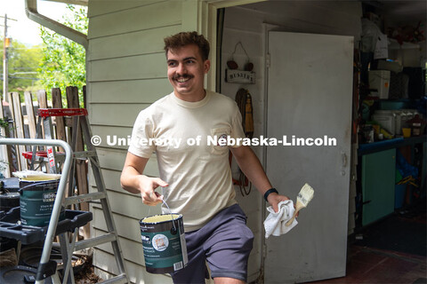 Pi Kappa Alpha’s Cole Gustafson gives a smile after completing the painting of the exterior of a g