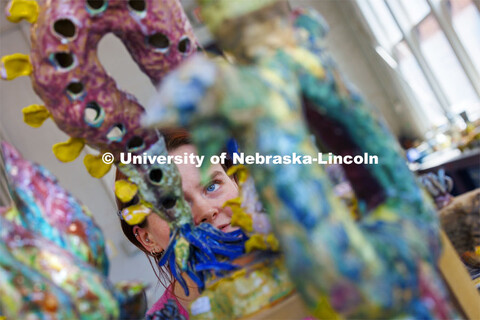 Taylor Powell looks over one of the clay artworks for sale in Richards Hall. End of year exhibitions