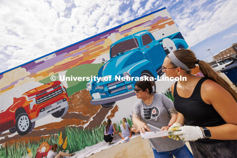 Sandra Williams, center, and Maddie Vanderbur, a senior in graphic design and the mural’s designer