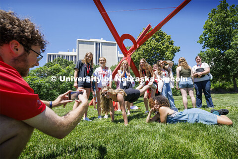 Jameson Margetts takes a photo of his NSE group in font of the Old Glory sculpture as they strike a 