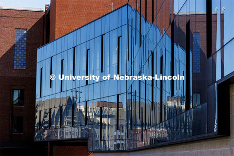 The Village and Harper Schramm Smith residence halls are reflected in the glass of the Engineering R