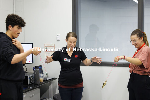 While Chira Khudhur, left, and Bella Thomas swing pendulums, Christine Wittich, Assistant Professor 