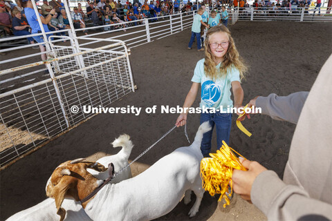 A young girl receives a yellow ribbon for her goat entry. 4-H Polk County Fair in Osceola, Nebraska.