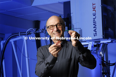 David Berkowitz holds an NMR tube, preparing to analyze the structure of a compound synthesized in h